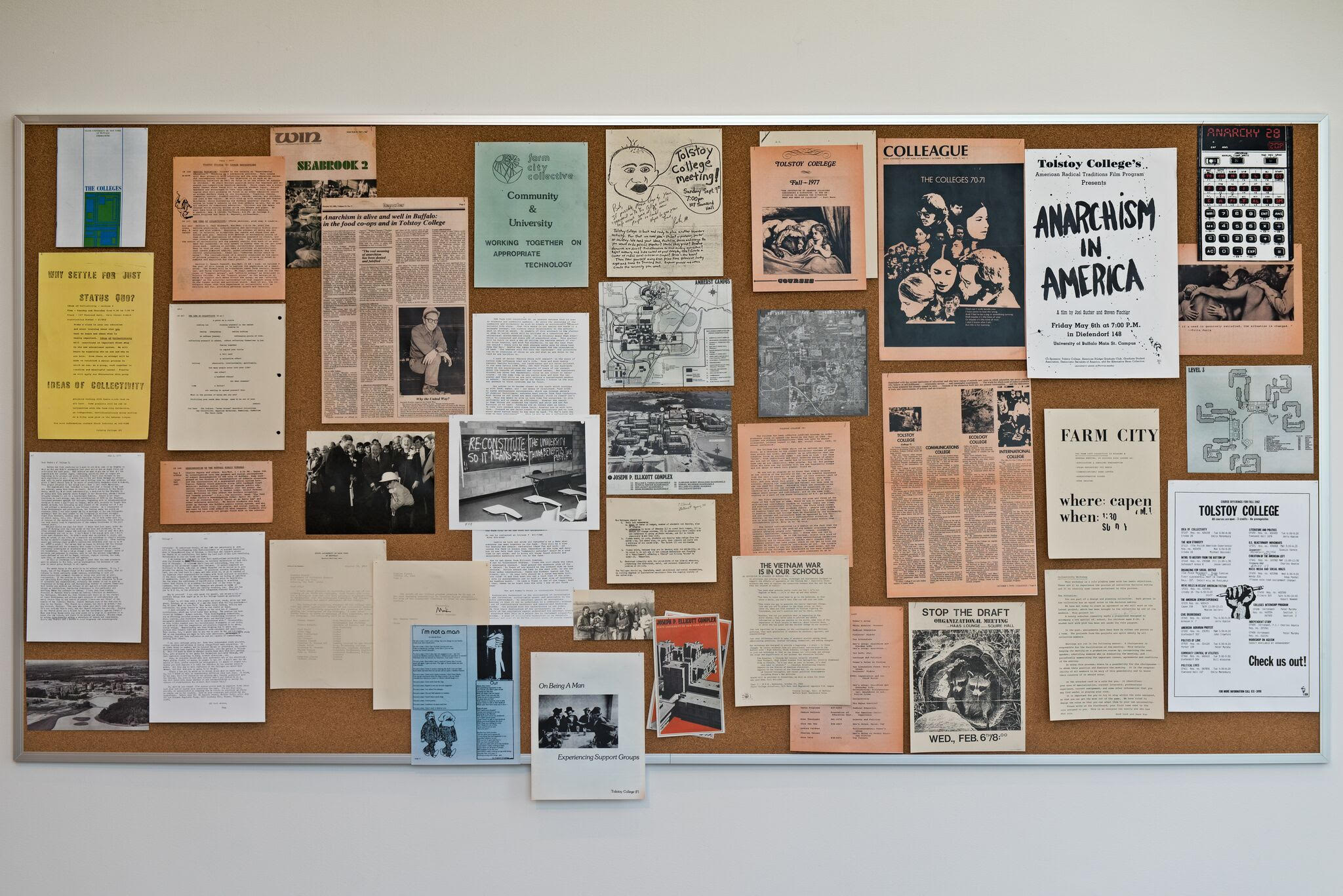 an image of a bulletin board displaying many pieces of ephemera collected from the University of Buffalo Archives on Tolstoy College